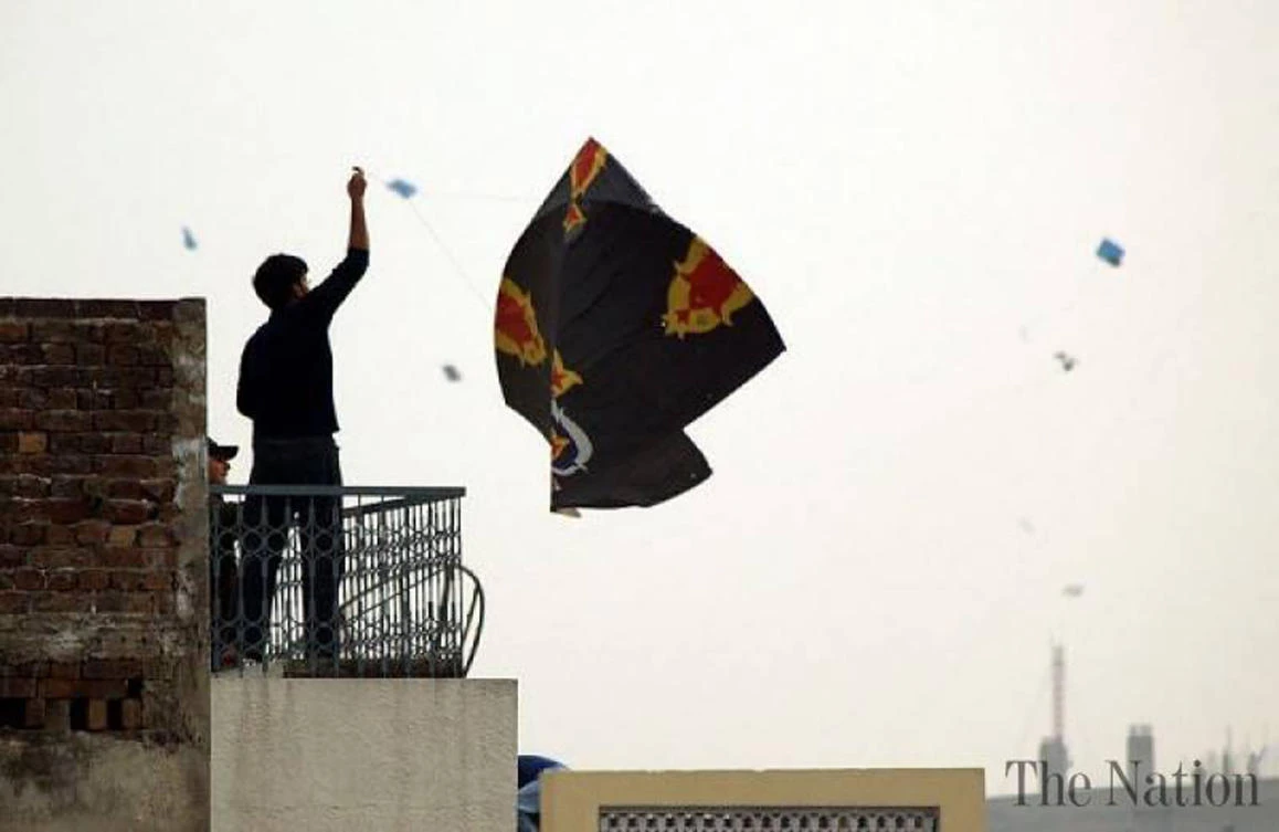 A man raising his kite up in the sky in the Old City, Lahore. (AN photo by Shafiq Malik)