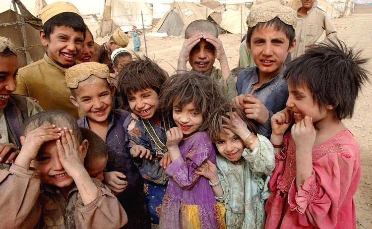 Unidentified Afghan children from the Kuchi nomadic tribe laugh despite horrible living conditions. (AFP)