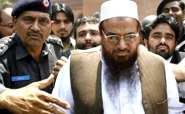 In this file photo, Police escort Hafiz Saeed, right, the head of the banned Jamaat-ud-Dawa, as he leaves after an appearance in court in Lahore on May 5, 2009. (REUTERS)