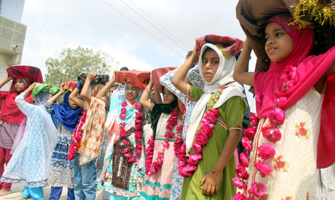 Young Sheedi girls carry homemade sweets to be distributed among devotees and attendees of the festival. (AN photos)