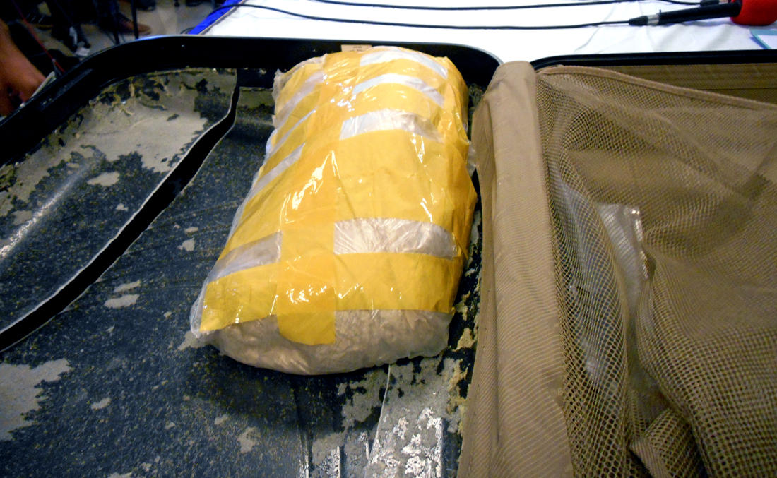 A 5kg pack of heroin inside a suitcase is displayed for media.