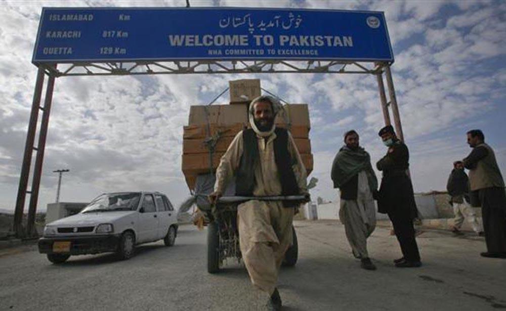 In this undated file photo, a Pashtun man passes a road sign while pulling supplies towards the Pakistan-Afghanistan border crossing. (REUTERS photo)