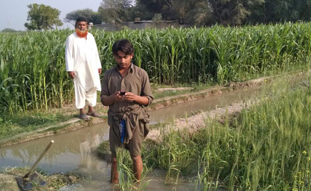 A Pakistani farmer checks his cell phone for weather updates and estimates of how much irrigation water he will need over the next few days.Punjab Government said on Monday it will provide free Android smartphones to 110,000 farmers in the province. The objective is to keep the farmers updated about the Agriculture Department’s recommendations about their crops. (Photo courtesy: Faisal Hossain and PCRWR)