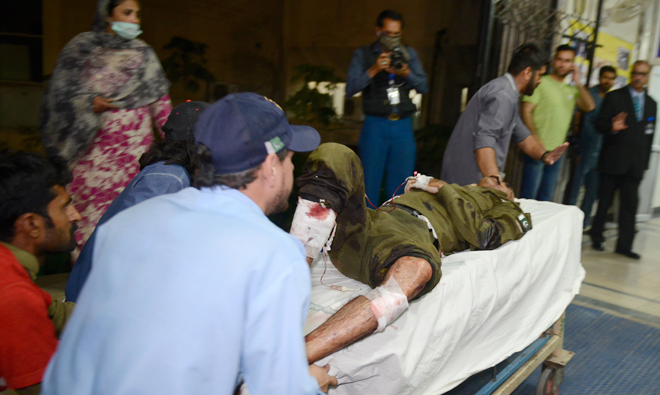 Pakistani rescue workers push a stretcher carrying an injured man to the hospital following the blast of a motorcycle bomb attack in Lahore on Mar. 14, 2018. (AFP)