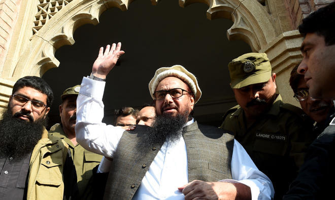 Pakistan head of the Jamaat-ud-Dawa (JuD) organization Hafiz Saeed waves to supporters as he leaves a court in Lahore. (AFP)