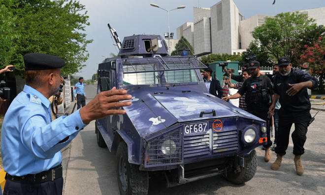 Pakistani journalists and security personnel surround the vehicle carrying former senior superintendent of police (SSP) Rao Anwar to police custody as it leaves the Supreme Court after a hearing in Islamabad on Mar. 21, 2018. (AFP)