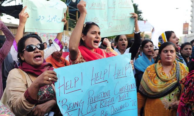 In this file photo, Pakistani minority Christians and civil society hold placards as they chant slogans protesting the murder of a Christian couple, in Karachi on Nov. 6, 2014. (AFP)
