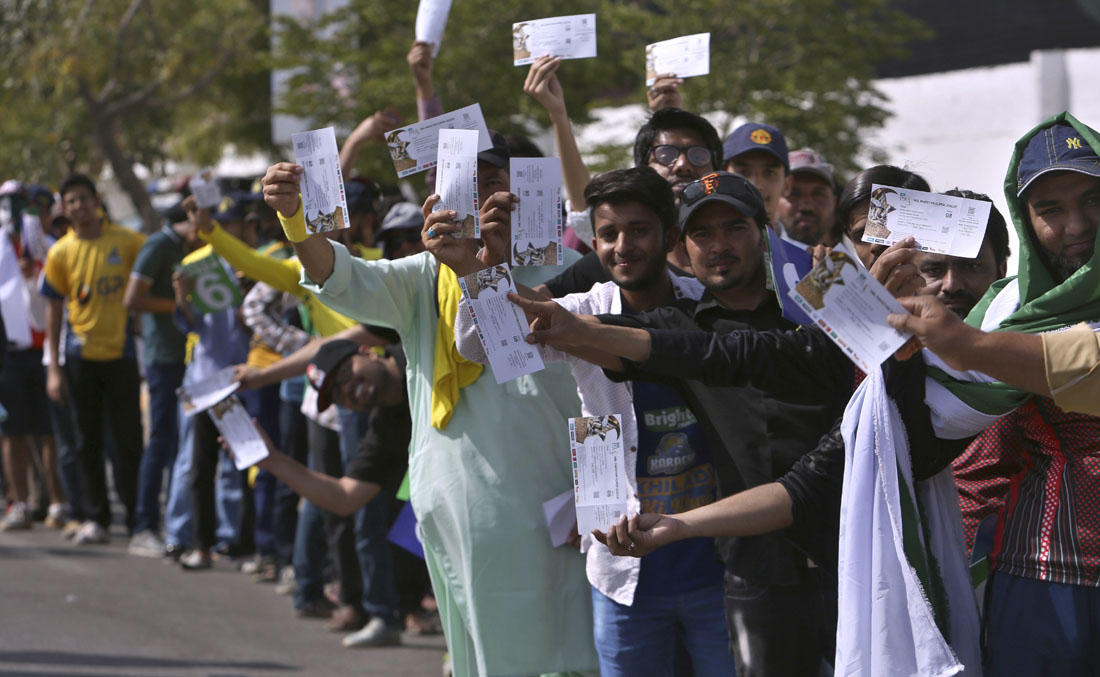 Cricket fans display their tickets while standing in a queue to enter in the National stadium for Pakistan Super League final cricket match in Karachi, Pakistan, Sunday, March 25, 2018. (AP)