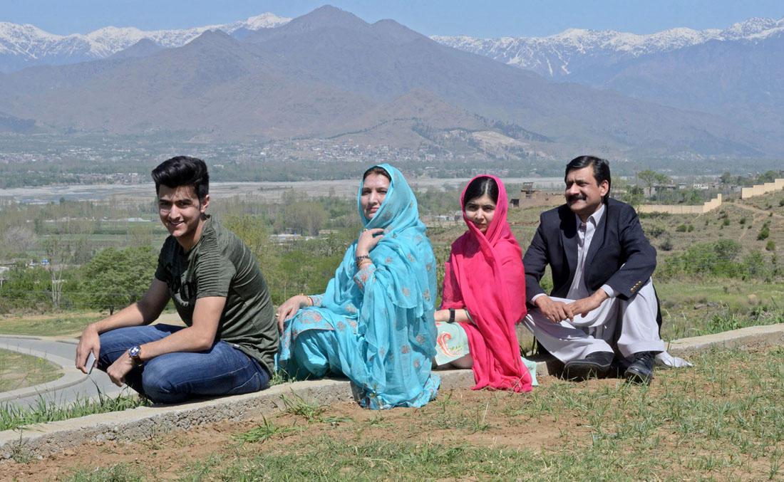 Pakistani activist and Nobel Peace Prize laureate Malala Yousafzai, second right, poses for a photograph along with her father Ziauddin Yousafzai, right, mother Torpekai, second left, and brother Atal Yousafzai at the all-boys Swat Cadet College Guli Bagh, during her hometown visit, some 15 kilometers outside of Mingora, on March 31, 2018. (AFP)