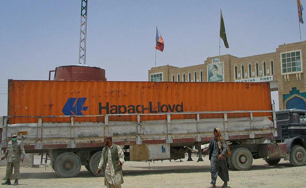 In this file photo, men walk past a truck carrying supplies for NATO troops in Afghanistan, as it crosses into Afghanistan from the Pakistan border town of Chaman July 5, 2012. (REUTERS)