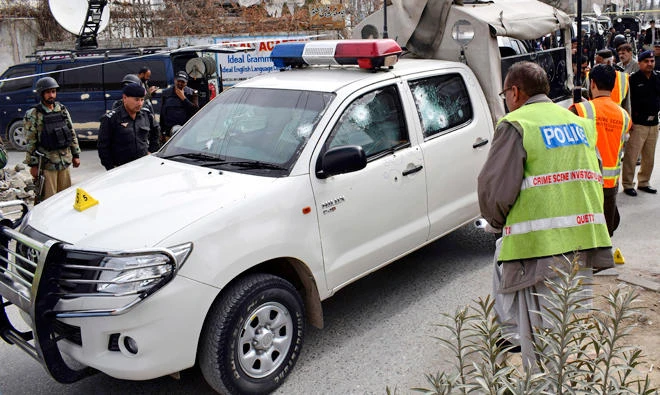 Pakistani police officers examine a bullet-riddled vehicle following an attack by a gunman in Quetta on Feb. 28, 2018.(AP Photo/Arshad Butt)
