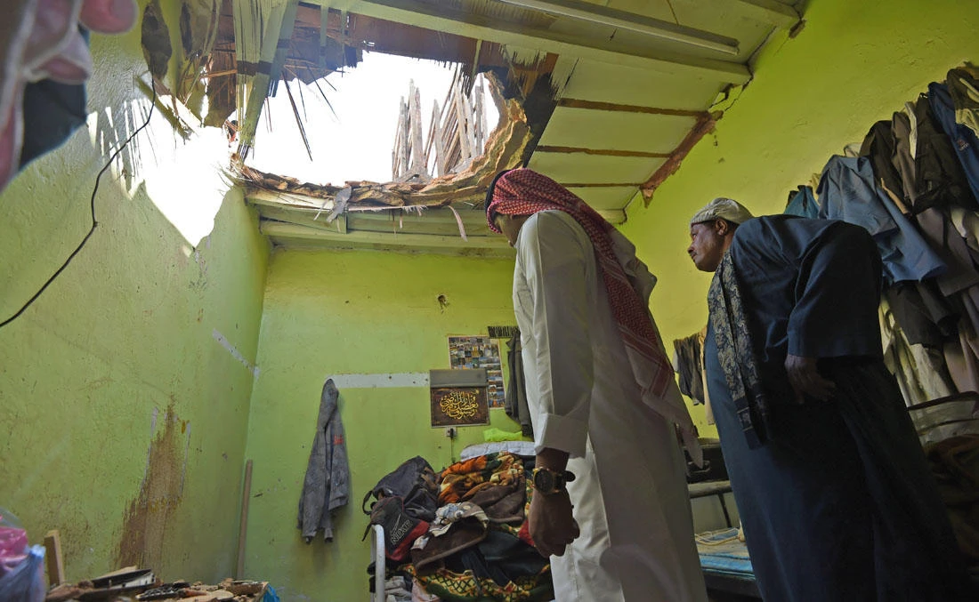 A picture taken March 26, 2018 in Um Al-Hammam district in Riyadh shows Egyptian laborers inspecting damages to a home hit by falling shrapnel from Yemeni rebel missiles that were intercepted over the Saudi capital. (AFP)