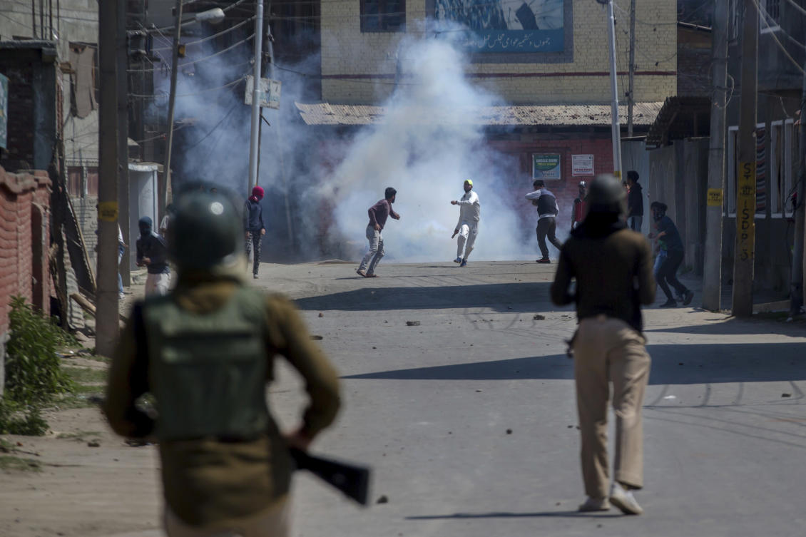 Kashmiri protesters engulfed in tear gas smoke clash with Indian paramilitary soldiers during a protest against the killing of rebels in Srinagar, Indian controlled Kashmir, Sunday, April 1, 2018. (AP)