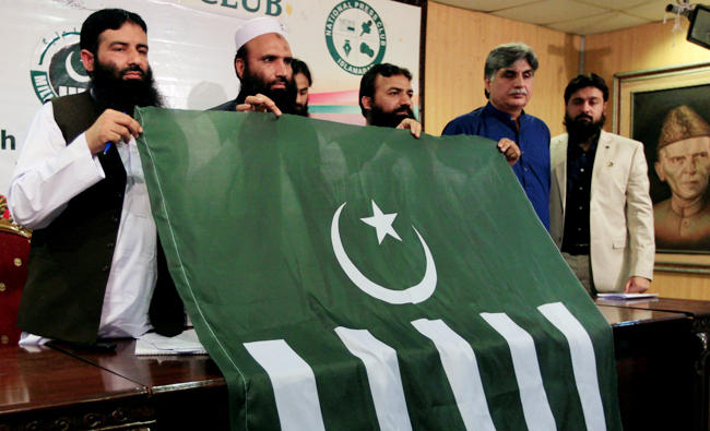 Saifullah Khalid (2nd L), President of Milli Muslim League (MML) political party, holds a party flag with others during a news conference in Islamabad, Pakistan August 7, 2017. REUTERS/Faisal Mahmood/File Photo