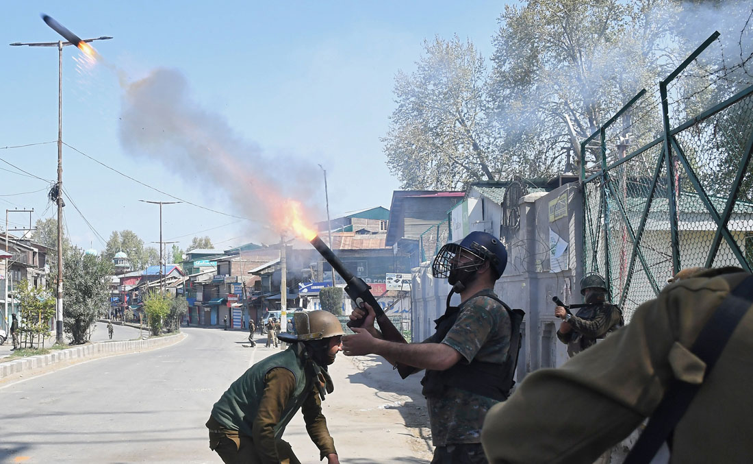 An Indian policeman fires a tear smoke shell towards protesters on Friday, in south Kashmir's Pulwama district, April 7, 2018. (REUTERS)