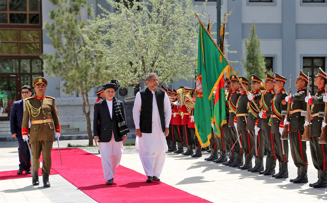 Afghanistan’s President Ashraf Ghani and Pakistani Prime Minister Shahid Khaqan Abbasi inspect the honor guard at the presidential palace in Kabul, Afghanistan April 6, 2018. (Presidential palace/Handout via REUTERS)
