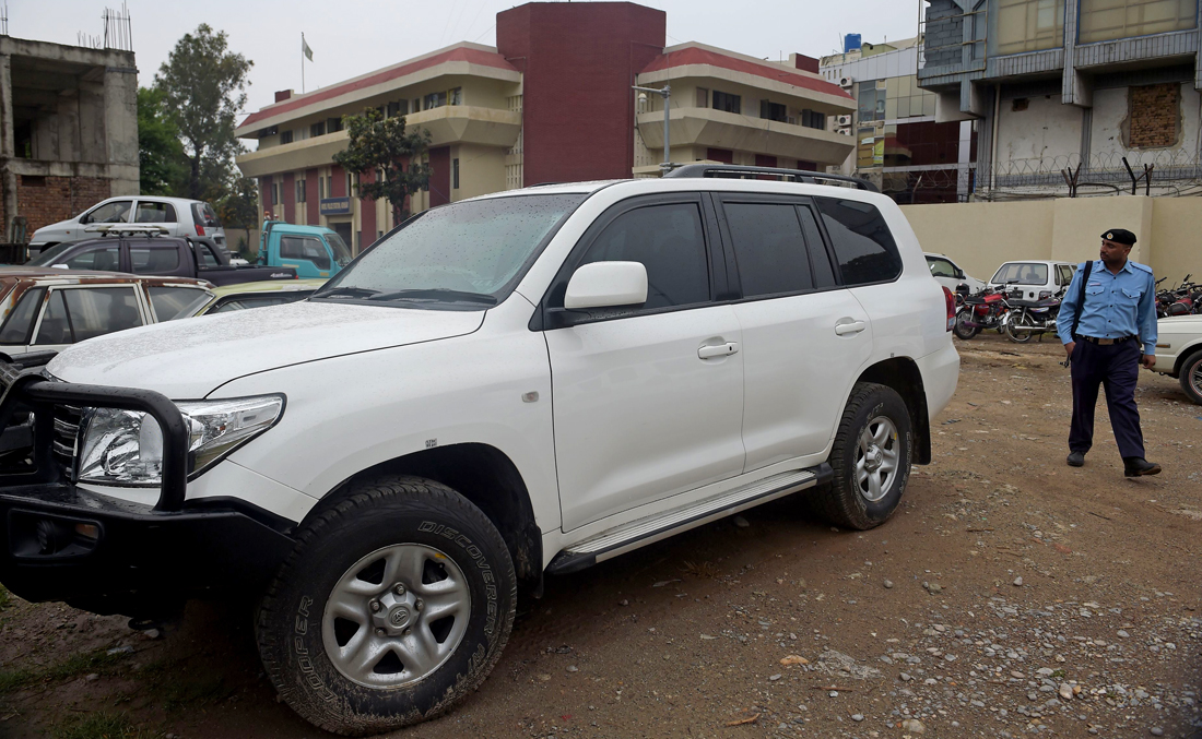 A Pakistani policeman walks past a car of an American diplomat parked inside a police station after an accident in Islamabad, April 8, 2018. (AFP)