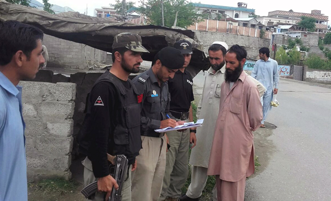 Policemen stand guard at a check post in Lower Dir district. (AN photos)