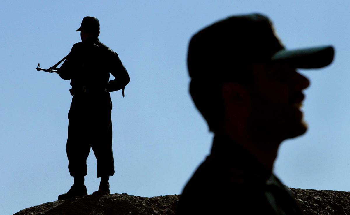 In this file photo, Iranian soldiers stand guard on a mound built to prevent drug trafficking in the Mirjaveh point where the borders of Iran, Afghanistan and Pakistan meet, on Dec. 2, 2003. (AFP)