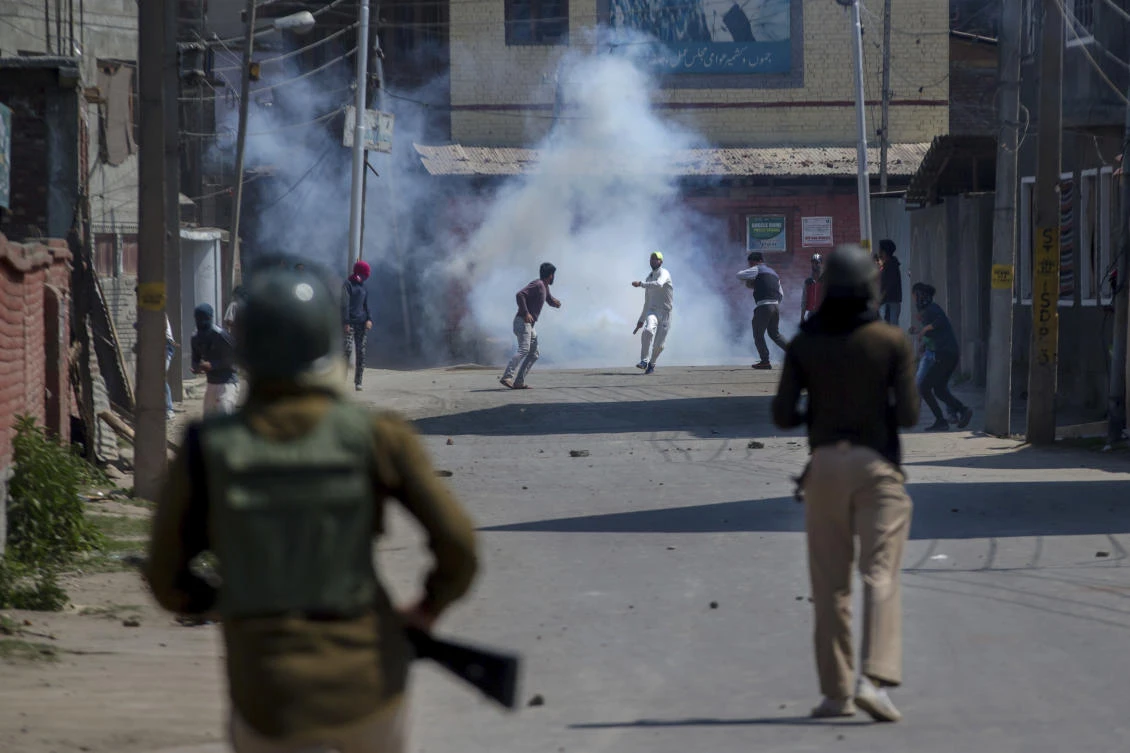 Kashmiri protesters engulfed in tear gas smoke clash with Indian paramilitary soldiers during a protest against the killing of rebels in Srinagar, Indian controlled Kashmir, Sunday, April 1, 2018. (AP)