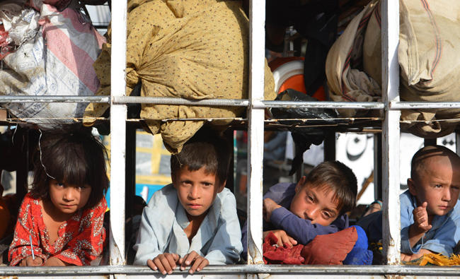 In this file photo, Pakistani children arrive by truck with some belongings in the neighborhood of Bannu, after fleeing North Waziristan tribal region in northwestern Pakistan on June 20, 2014 following a Pakistani army offensive against militants. (AFP)