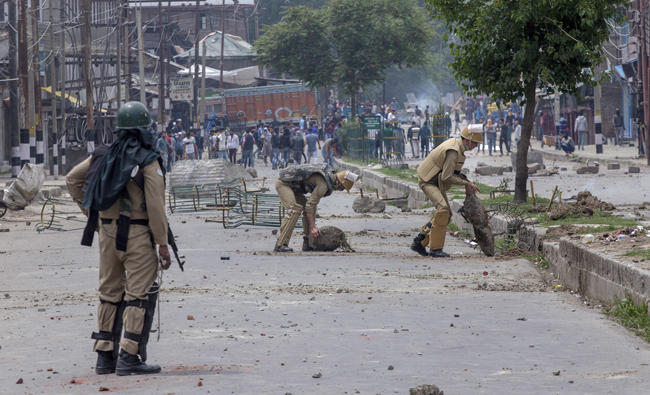 Indian policemen remove rocks, set up as barricade by Kashmiri protesters, near the site of a gun battle in Srinagar, Indian controlled Kashmir on May 5, 2018. (AP)