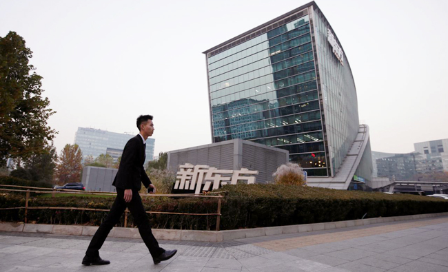 In this file photo, A man walks past New Oriental Education & Technology Group headquarters in Beijing, China. (REUTERS)