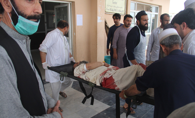An Afghan wounded man lays on a trolley as others rush him to a hospital following blast at a voter registration center in Khost Province on May 6, 2018. (AFP)