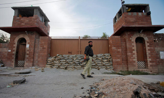 A police officer walks past Central Jail in Peshawar in this file photo. Police say an explosion at a hotel has killed five people from one family and wounded two other people in Peshawar. (REUTERS File Photo)