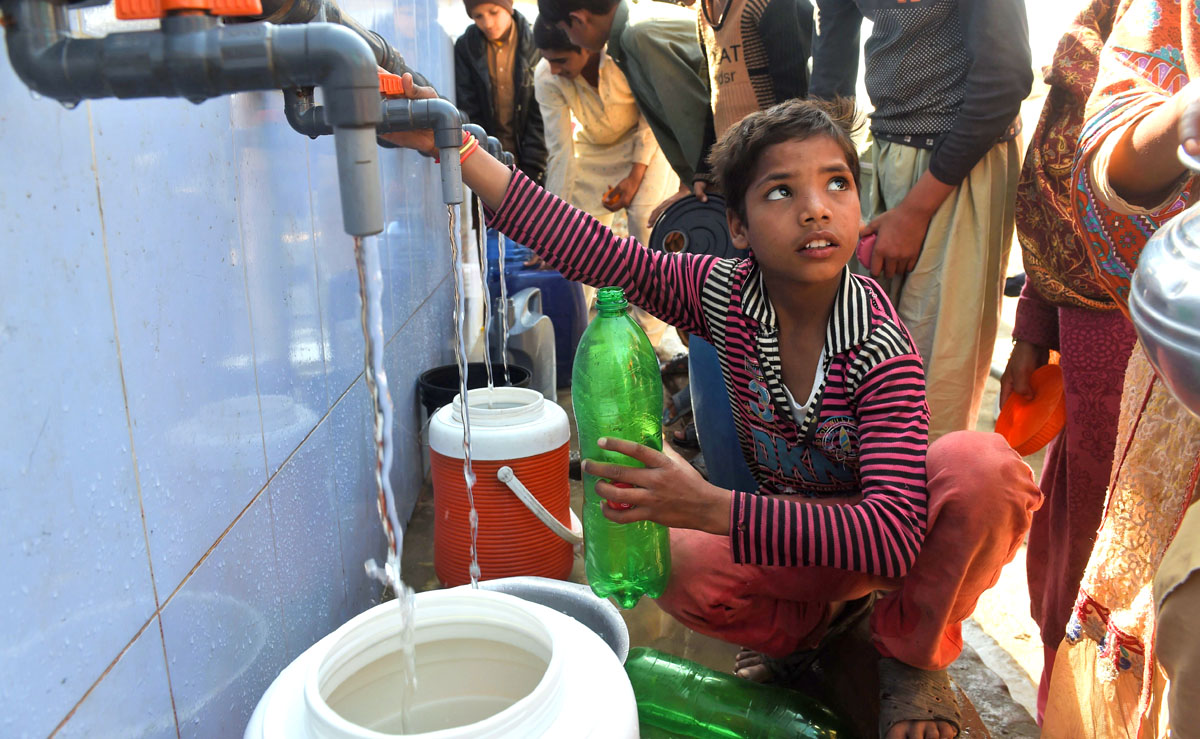 In this file photo, Pakistani residents fill their cans with drinking water from a filtration plant donated by the Junaid Jamshed foundation in Kot Assadullah on Feb. 25, 2018. (AFP)