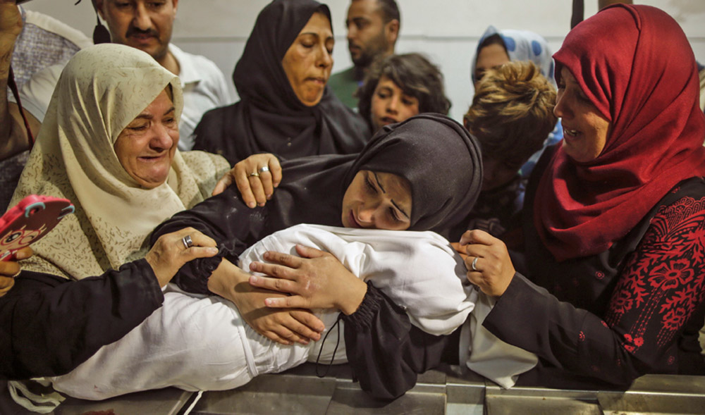 The mother of a Leila Al-Ghandour, center, a Palestinian baby of 8 months who according to the Palestinian health ministry died of tear gas inhalation during clashes in East Gaza, holds her at the morgue of Al-Shifa hospital in Gaza City on May 15, 2018. (AFP)