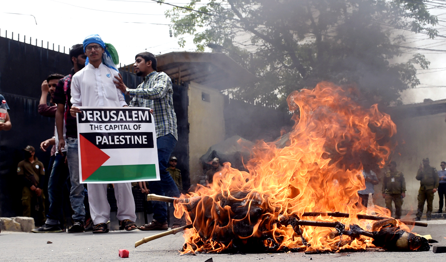 Pakistani students from religious group Islami Jamiat-e-Talaba gather beside a burning effigy of the US President Donald Trump outside the US consulate during a protest against United States and Israel in Lahore on May 15, 2018. (AFP)