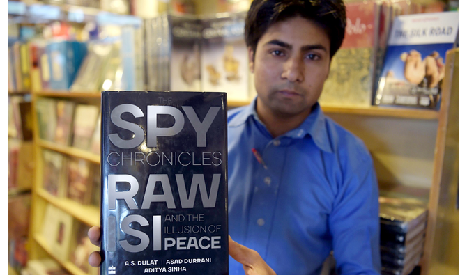A Pakistani salesman shows "The Spy Chronicles: RAW, ISI and the Illusion of Peace", book wrote by Asad Durrani, retired Pakistani Lieutenant General, at a book store in Islamabad on May 30, 2018. Pakistan's military on May 28 took the unprecedented step of preventing a former spy chief from leaving the country, after he ignited a storm by co-authoring a book that touches on Pakistan's alleged roles in Afghanistan and Kashmir. (AFP)