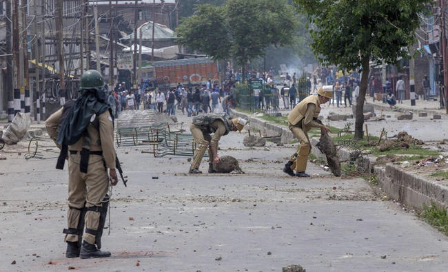 Indian policemen remove rocks, set up as barricade by Kashmiri protesters, near the site of a gun battle in Srinagar, Indian controlled Kashmir on May 5, 2018. (AP)