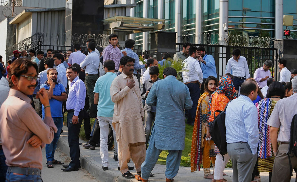 People stand outside their office building after a 6.2 earthquake is felt in Islamabad, Pakistan, Wednesday, May 9, 2018. (AP)