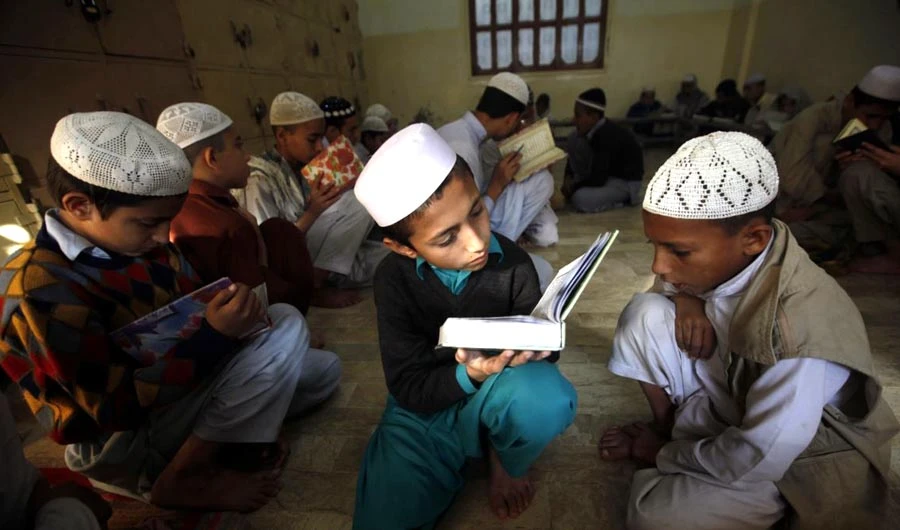 A student, right, recites as others listen to him while they are memorizing the Qur’an at the Jamia Binoria Al-Alamia Seminary Islamic Study School in Karachi, Dec. 10, 2012. (REUTERS)