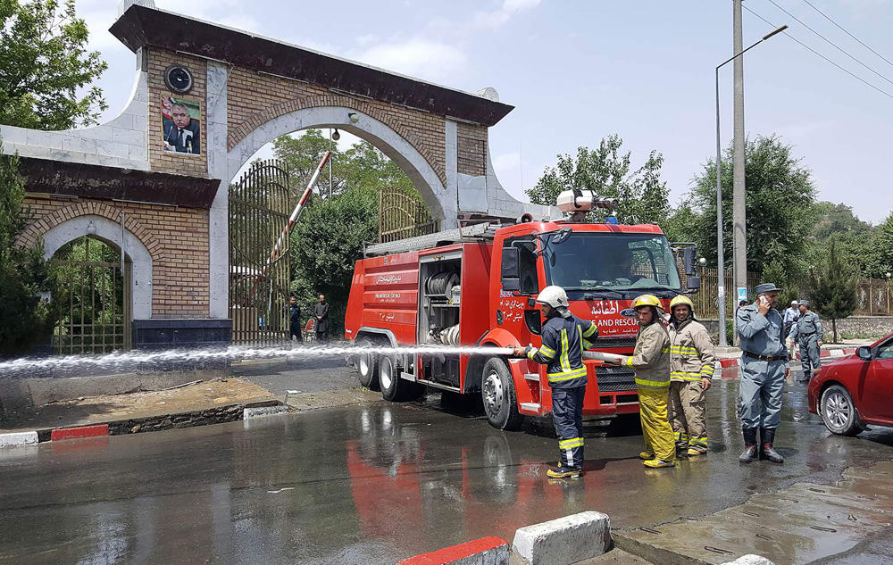 Afghan firefightera wash the road at the site of a suicide attack in the gates of Kabul's Polytechnic University in Kabul on June 4, 2018. (AFP / Ahmad Zafar)
