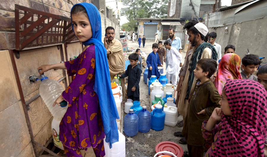 People wait for their turn to fill containers with clean water in Rawalpindi, Pakistan, on June 5, 2018. Pakistanis are facing a shortage of clean drinking water due to the low level of water in the country's dams caused by the hot summer and a lack of rainfall. (AP)