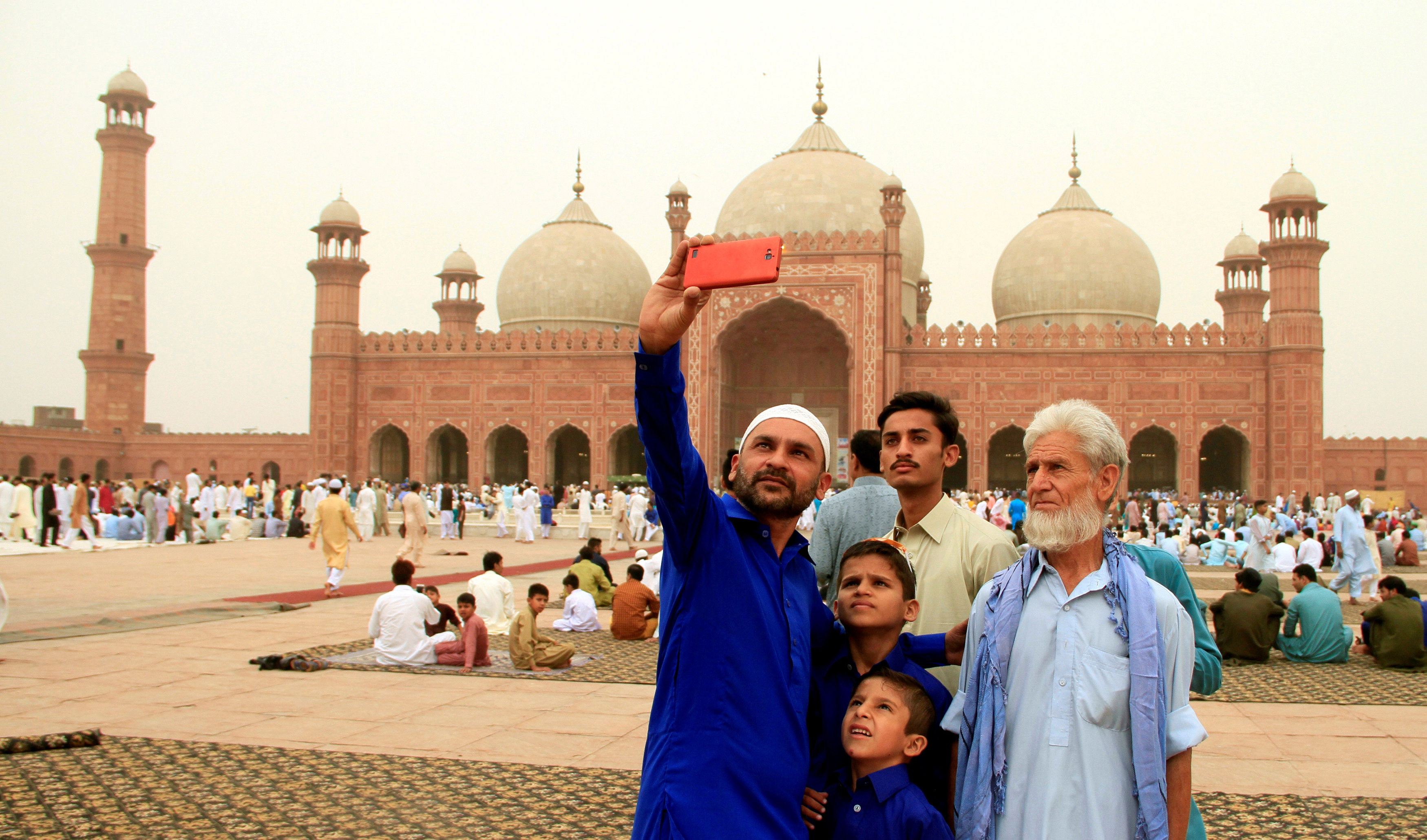 People take selfie as they attend Eid al-Fitr prayers at the Badshahi Mosque in Lahore, Pakistan June 16, 2018. (Mohsin Raza/REUTERS)
