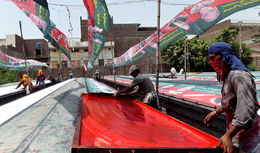 Pakistani workers prepare election banners featuring images of Imran Khan, cricketer-turned-opposition leader and head of the Pakistan Tehreek-i-Insaf (PTI) party in Lahore on June 26, 2018. (AFP)