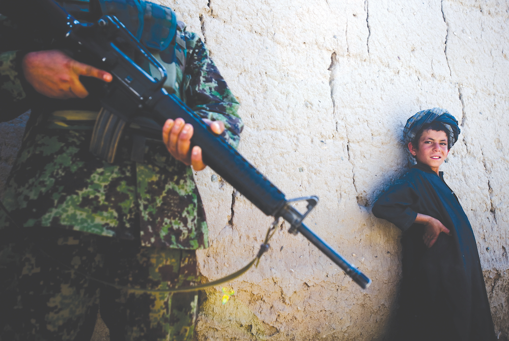 A Pashtun boy warily eyes an Afghan government soldier in Zabul province, southern Afghanistan. The region is at the heart of a bitter fight for supremacy between Taliban and Daesh rivals. (AN Photo/Chris Sands)