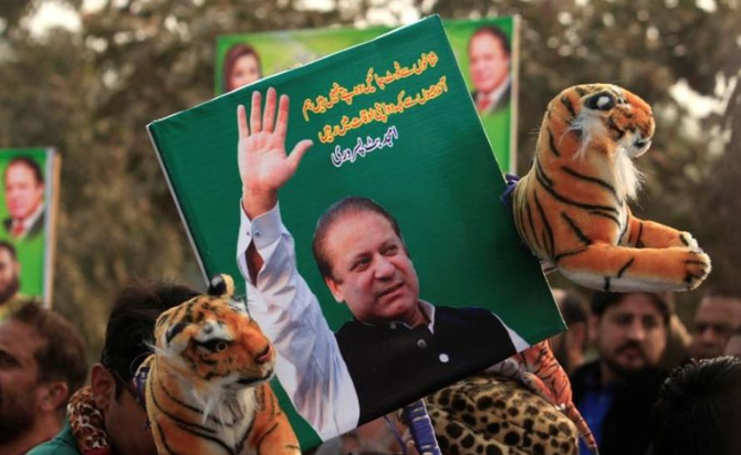 In this file photo, a supporter of the ruling Pakistan Muslim League-Nawaz (PMLN) holds a picture of Nawaz Sharif outside the accountability court, in Islamabad, Pakistan, Nov. 3, 2017. (REUTERS)