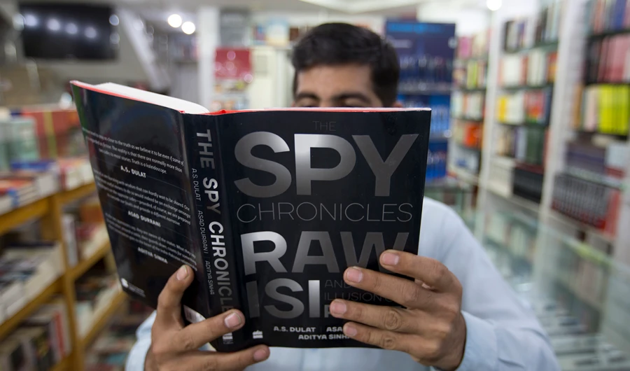 A Pakistani customer looks at a book "Spy Chronicles" at a book store in Islamabad, Pakistan, on June 1, 2018. (AP)