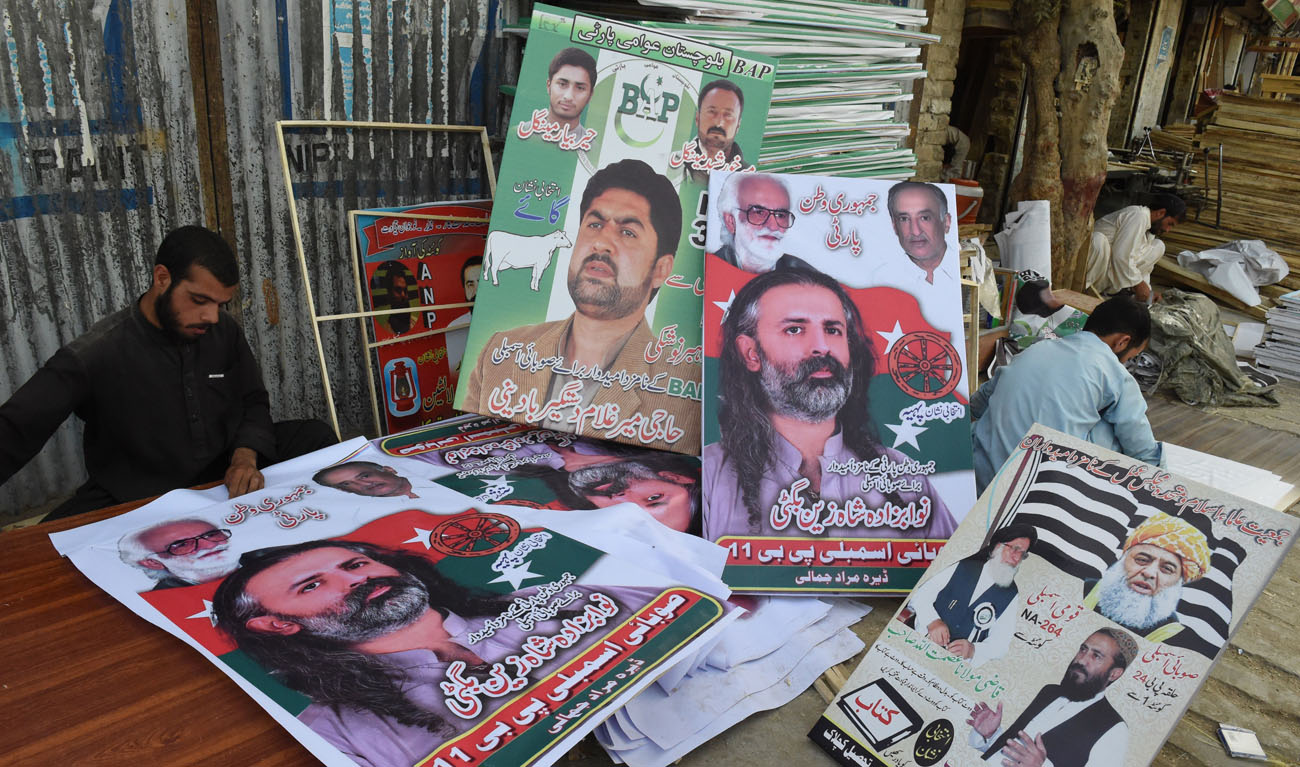 Posters of political parties for Pakistan’s July 25 election are prepared in Quetta. (BANARAS KHAN/AFP)