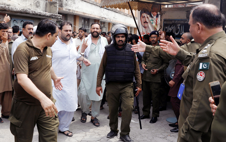 Supporters of the Pakistan-Muslim League - Nawaz (PML-N) who were arrested after holding a rally to obstruct the arrest of Mohammad Safdar, son-in-law of of ousted Prime Minister Nawaz Sharif, are handcuffed and escorted by police after they were appeared before district court in Rawalpindi, Pakisan on July 11, 2018. (REUTERS)