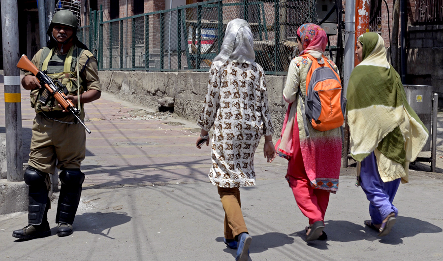 In this file photo taken on July 07, 2018, Indian paramilitary trooper stands guard as Kashmiri girls walk past during a one-day strike in Srinagar. (AFP)