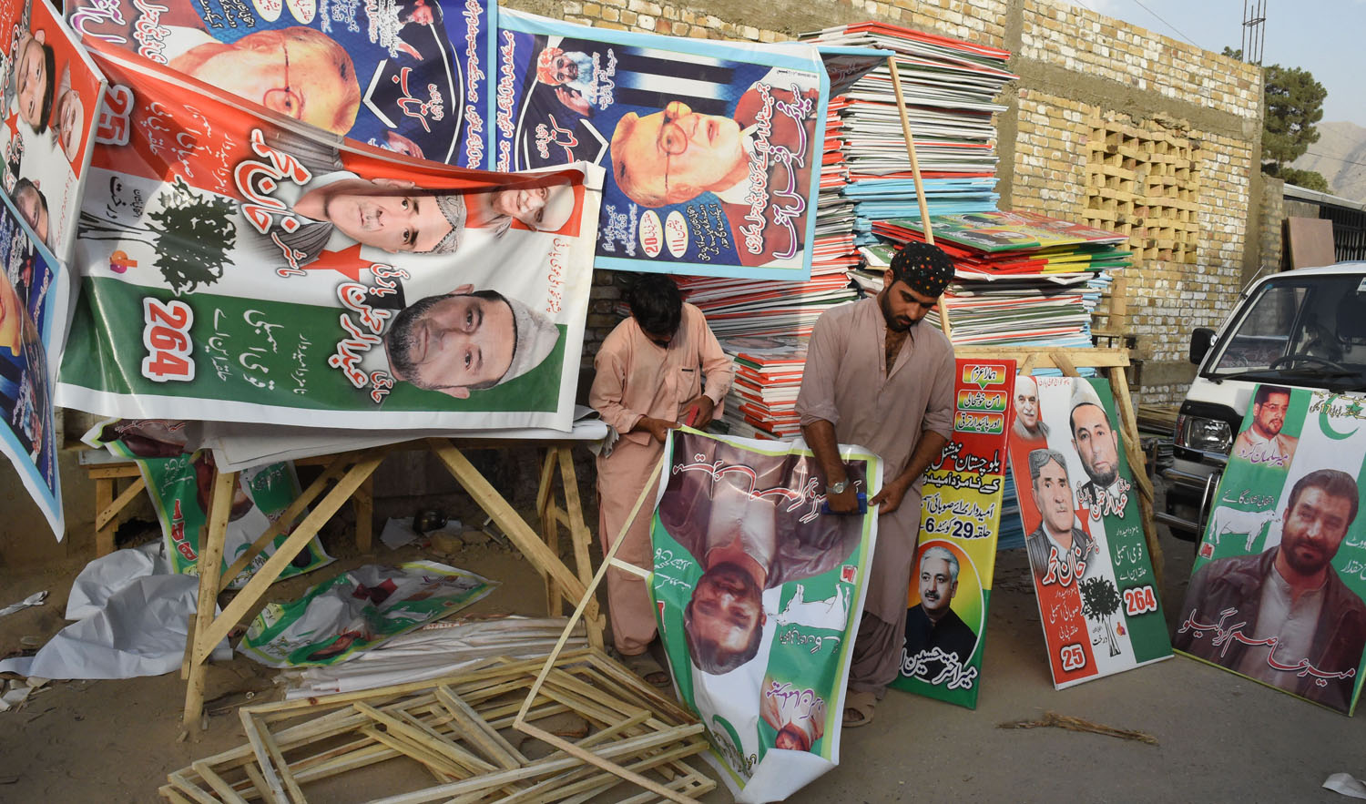In this file photo, Pakistani workers prepare posters of political parties for the upcoming general election in Quetta on June 30, 2018. (BANARAS KHAN/AFP)