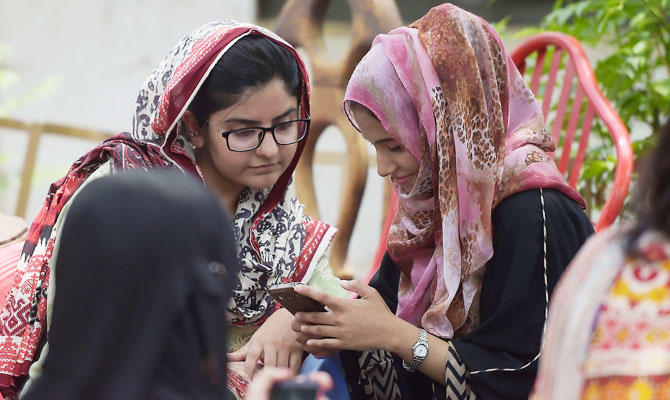 In this photo taken on July 12, 2018, students use their mobile phones at a campus in Islamabad. (AFP)