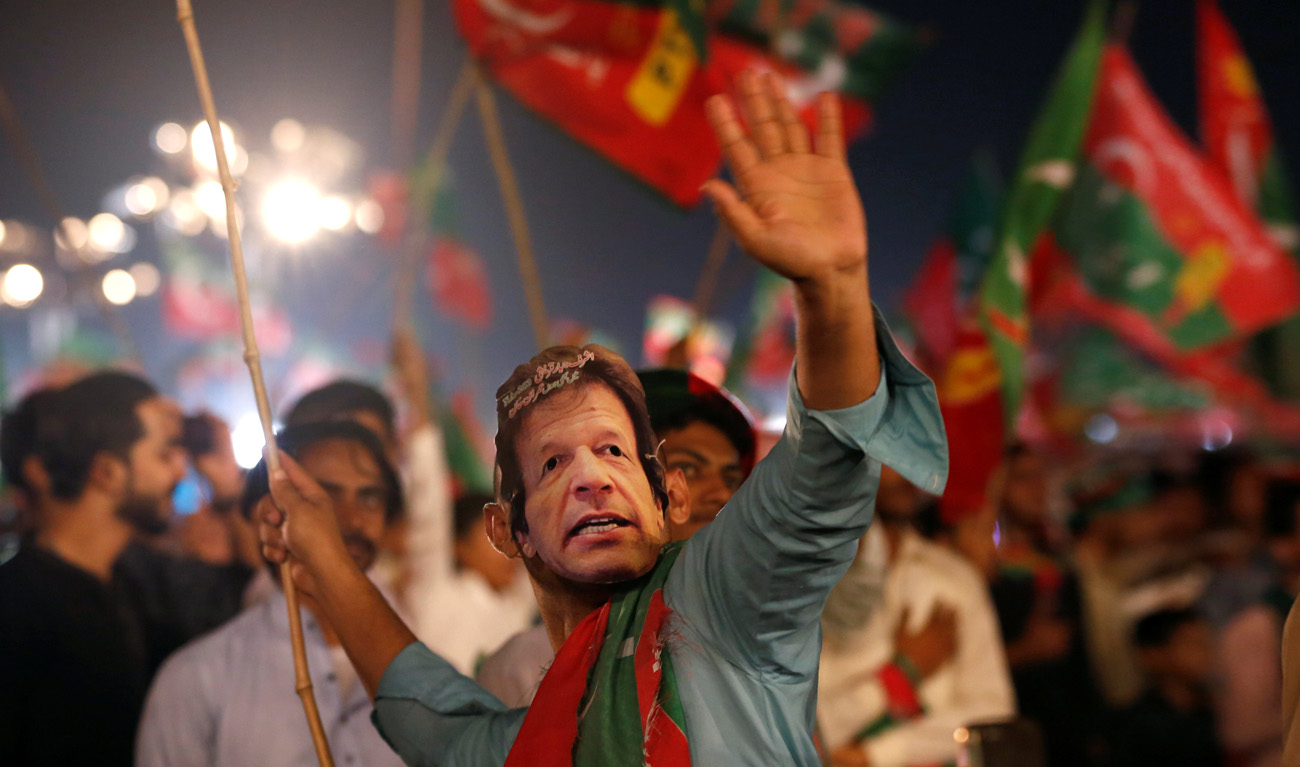 A supporter of Imran Khan, chairman of the Pakistan Tehreek-e-Insaf (PTI), political party, wears a mask and dance on party songs during a campaign rally ahead of general elections in Karachi, Pakistan July 22, 2018. (AKHTAR SOOMRO/REUTERS)