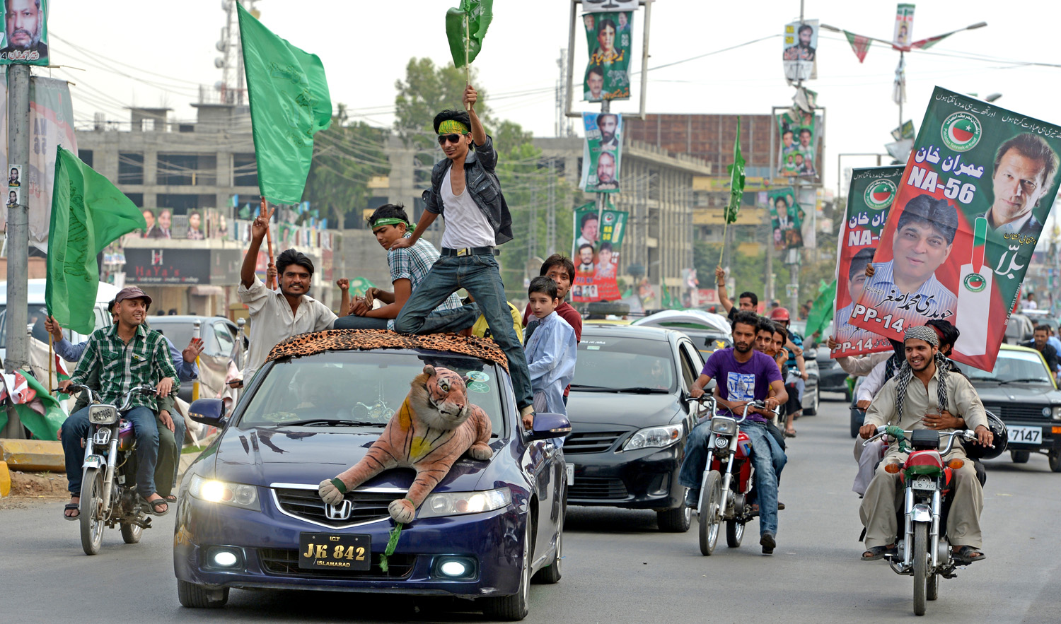 In this file photo, activists of Pakistan Tehreek-e-Insaf (PTI) and Pakistan Muslim League Nawaz (PML-N) parties carry posters and flags as they drive during the general election in Rawalpindi on May 11, 2013. (FAROOQ NAEEM/AFP)